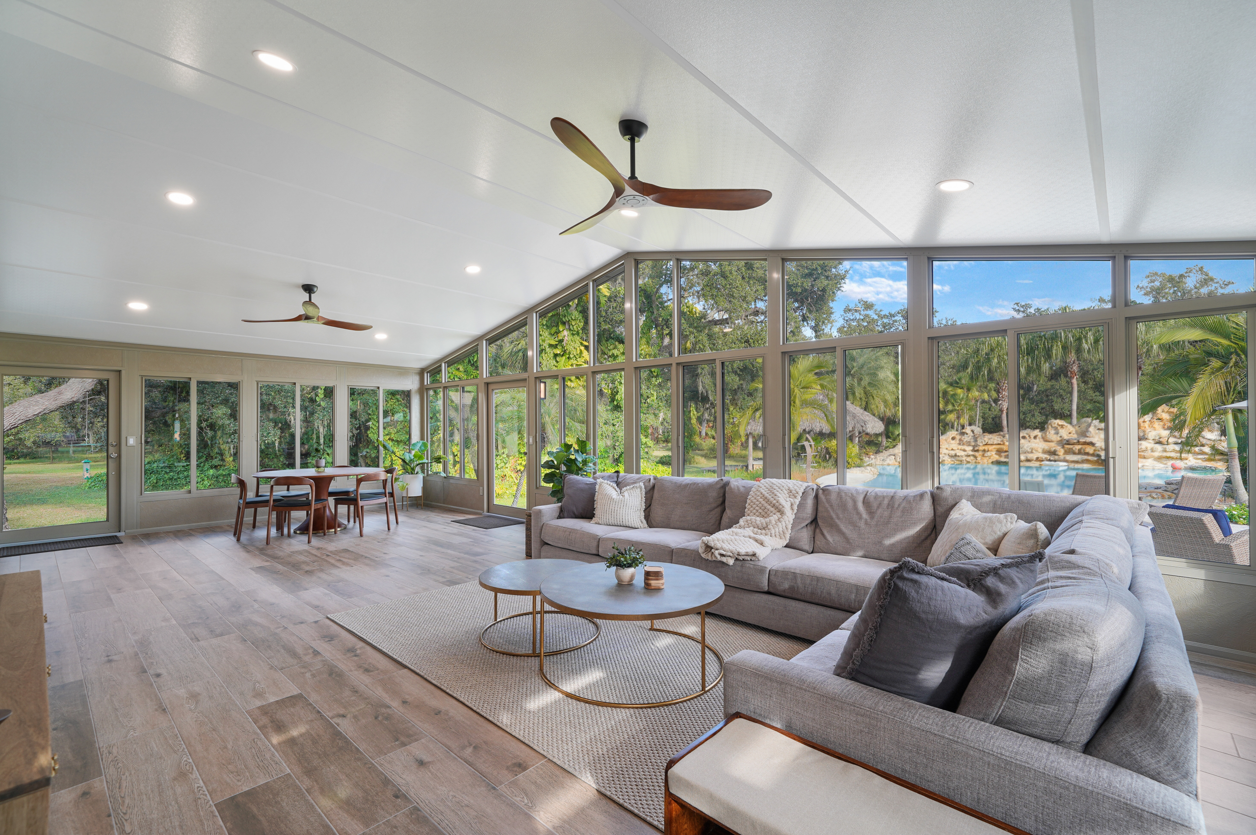 cathedral sunroom with vaulted ceilings, expansive glass walls, sun-filled enclosed patio, wide backyard views, open family space