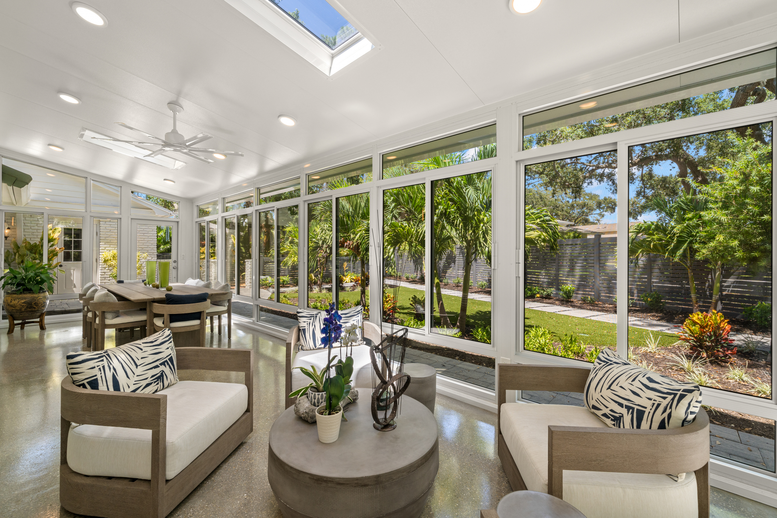 greenery-filled sunroom with wood finishes, floor-to-ceiling windows, cozy textures, florida outdoor space meets indoor comfort 